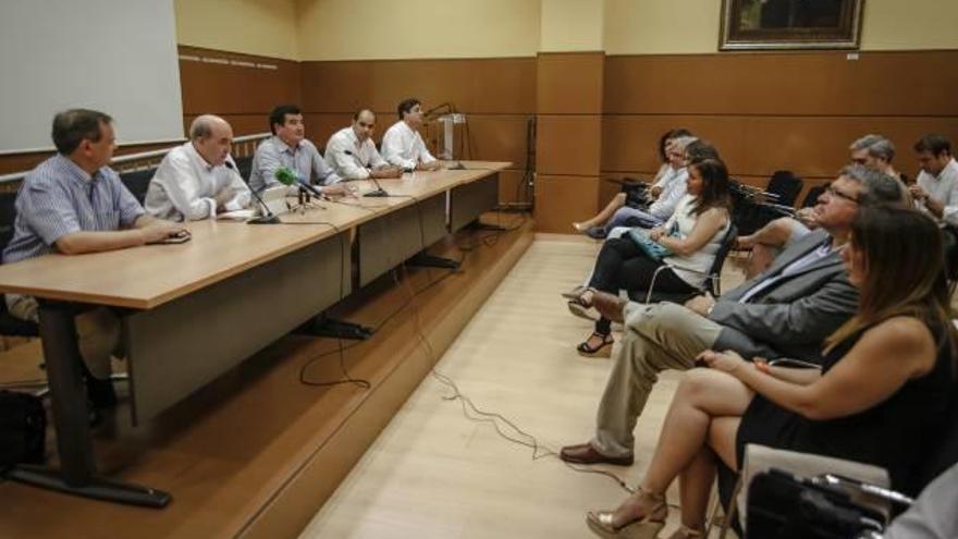 Fernando Llopis, a la derecha, escucha a los dirigentes de su partido, ayer en la sede de la UA.
