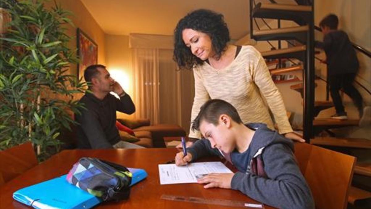 Irene Castilla, junto a su hijo David, en su casa. Al fondo, el padre, José del Caño, y el benjamín de la familia, Óscar.