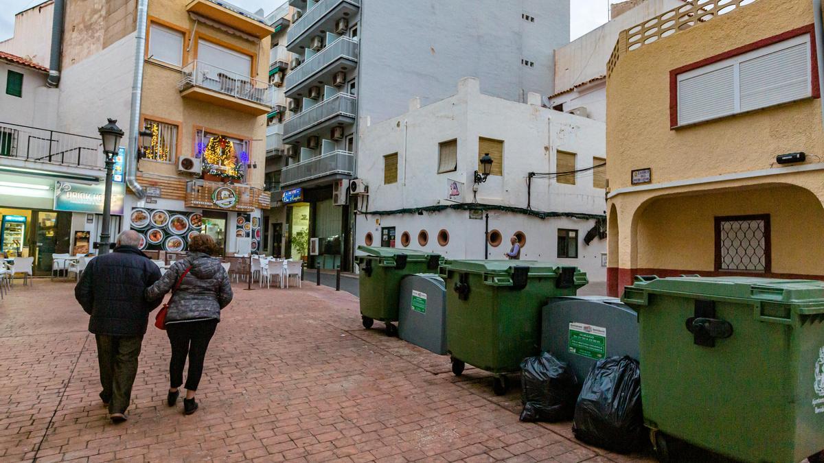 Una ristra de contenedores y bolsas de basura en pleno centro de Benidorm. Desde hace meses, se estableció un sistema de &quot;quita y pon&quot; de cubos en algunas zonas del casco antiguo para evitar esta imagen las 24 horas del día.