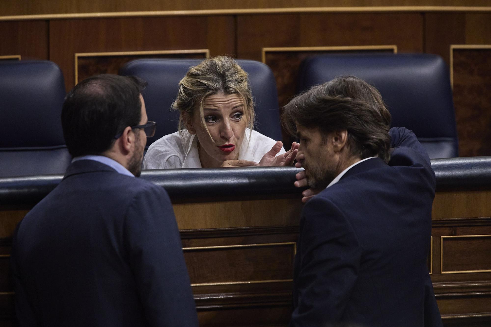 El ministro de Consumo, Alberto Garzón; la vicepresidenta segunda y ministra de Trabajo y Economía Social, Yolanda Díaz y el presidente del grupo parlamentario de Unidas Podemos y En Comú Podem en el Congreso, Jaume Asens, conversan durante una sesión plenaria en el Congreso de los Diputados, a 27 de octubre de 2022.