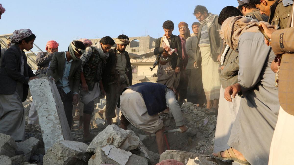 Varios hombres tras los ataques de Estados Unidos a los hutíes de Yemen