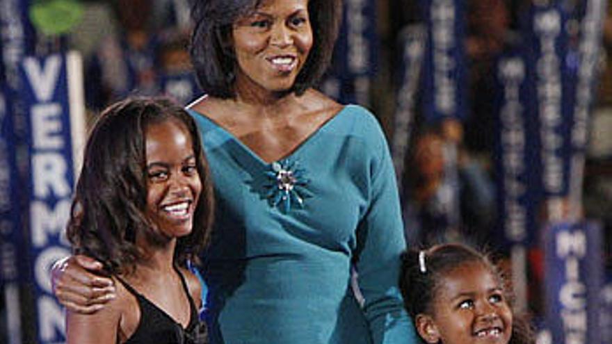 Malia, izquierda, y Sasha junto a su madre, Michelle Obama.