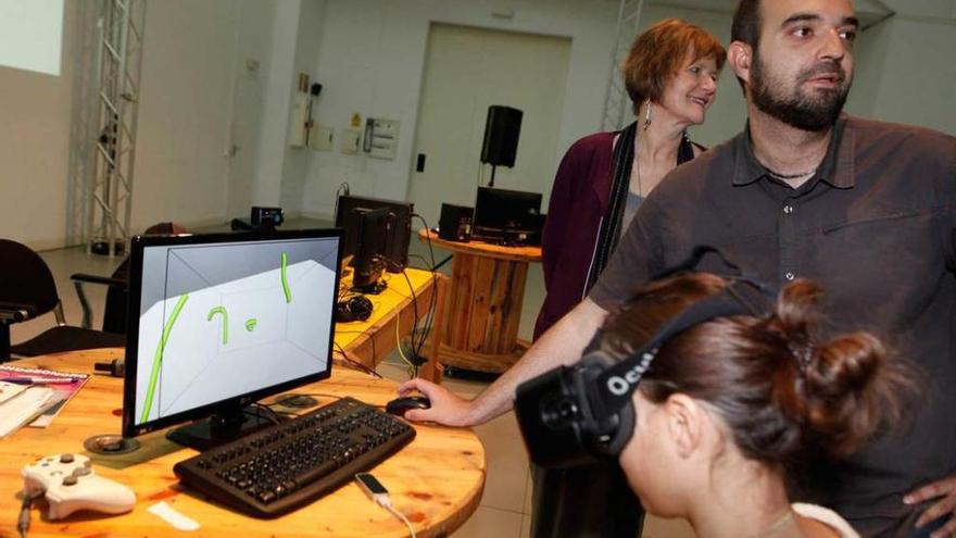 José Luis Rubio Tamayo explica ante Karin Ohlenschläger, directora de actividades de Laboral Centro de Arte, cómo funcionan las gafas de realidad virtual utilizadas en el proyecto.