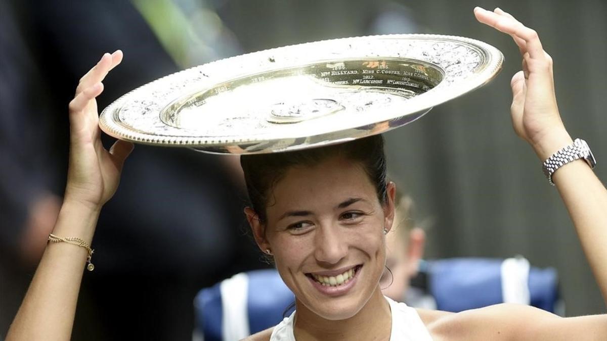 Garbiñe Muguruza bromea con el trofeo tras su gran victoria ante Venus Williams.