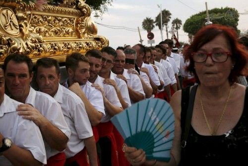 Men in traditional costumes carry a statue of the El Carmen Virgin on its way to be carried into the sea during a procession in Malaga