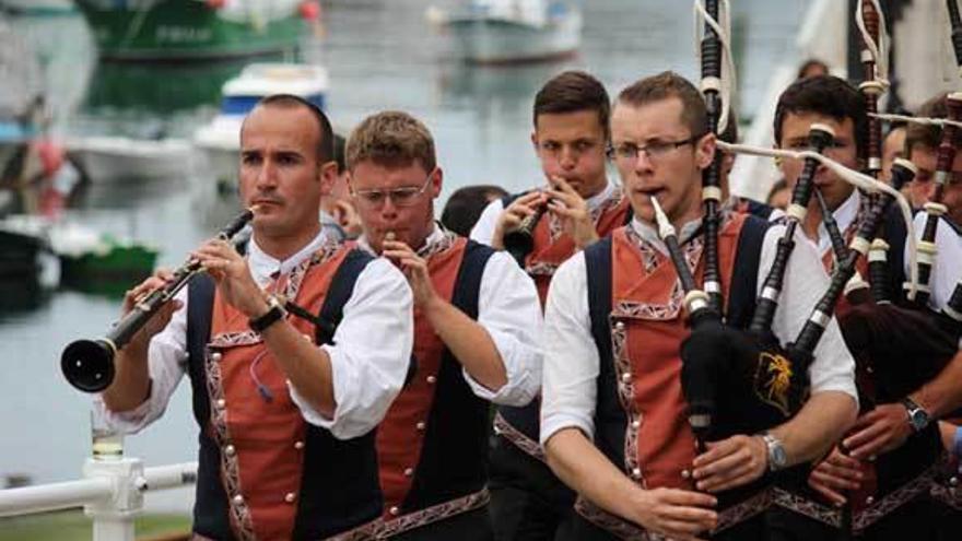 Arriba, la banda &quot;Airiños de Fene&quot; durante el desfile. A la izquierda, músicos de la banda bretona.