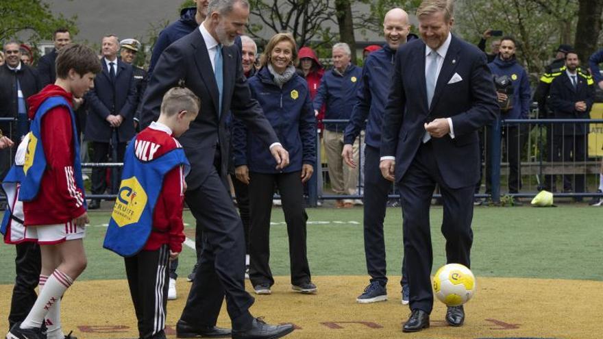 Spain's King Felipe VI, left, and Dutch King Willem-Alexander, right, do the kick-off for a soccer match during a visit to the Johan Cruyff Foundation in Amsterdam, Netherlands, Wednesday, April 17, 2024. (AP Photo/Peter Dejong)