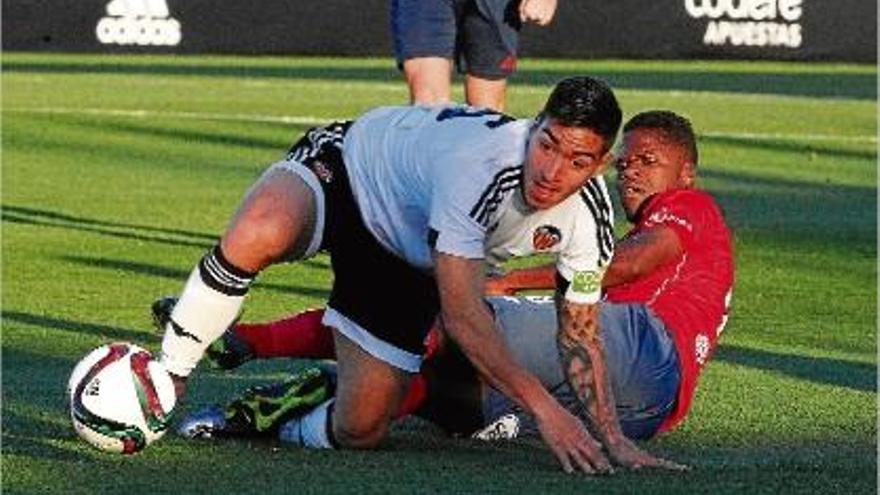 Sana lluita una pilota per terra amb un jugador del València Mestalla.