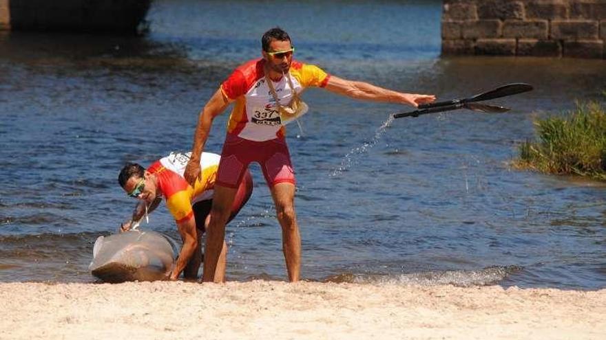 Walter Bouzán arroja la pala rota mientras Fiuza achica el agua de la kayak, antes del primer porteo.