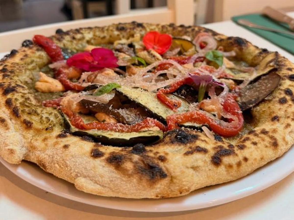 Pizza d'escalivada vegana, elaborada amb crema de carabasseta, verdures grillades, formatge vegà i nous pacanes.