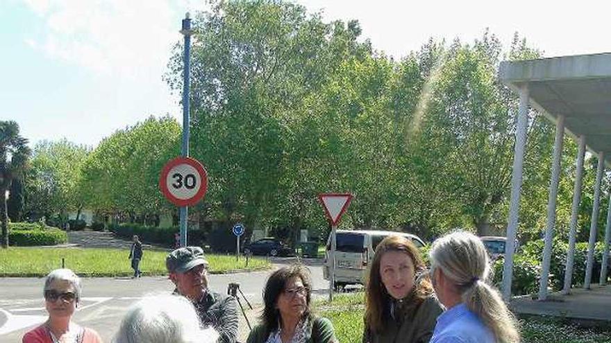 Lorena Gil, segunda por la derecha, habla con Carlos López, rodeados de compañeros, ayer, en Perlora.