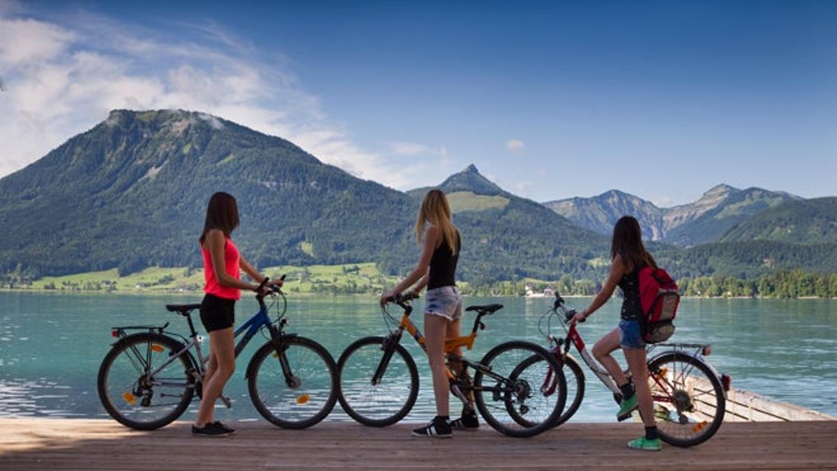 Jóvenes con sus bicis contemplan las vistas al lago Wolfgangsee en St. Wolfgang.