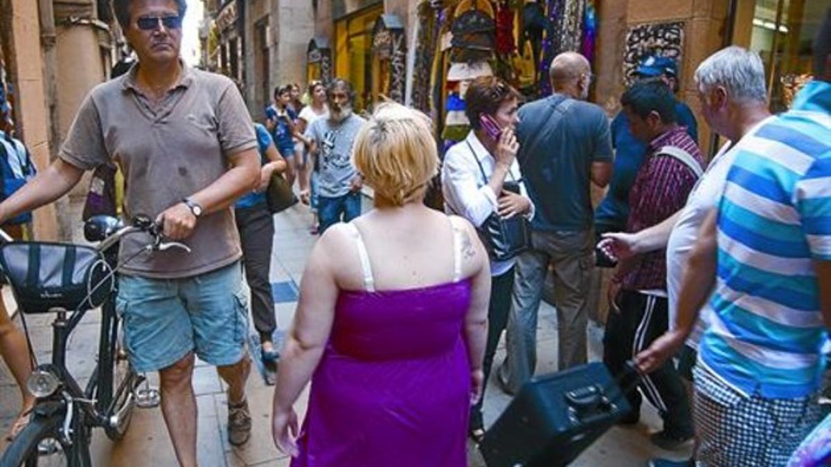 Paseantes y compradores, en una de las pequeñas y concurridas calles del Gòtic.