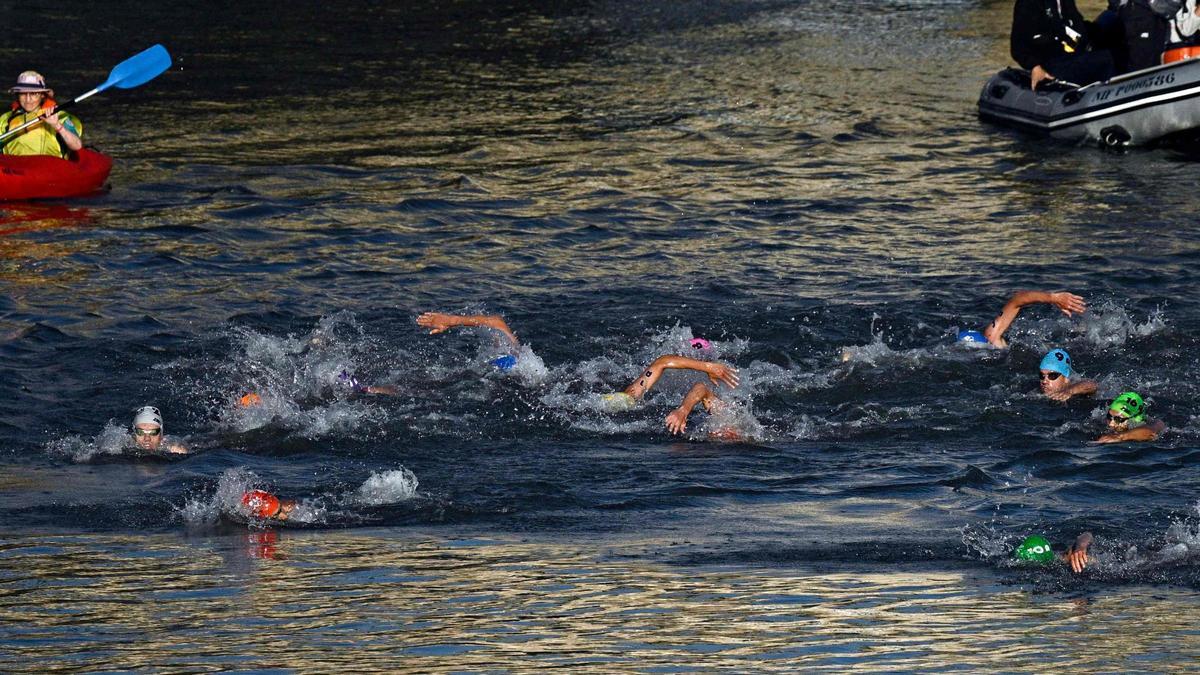 Los atletas compiten en la carrera de natación en el Sena durante el triatlón de relevos mixtos en los Juegos Olímpicos de París 2024