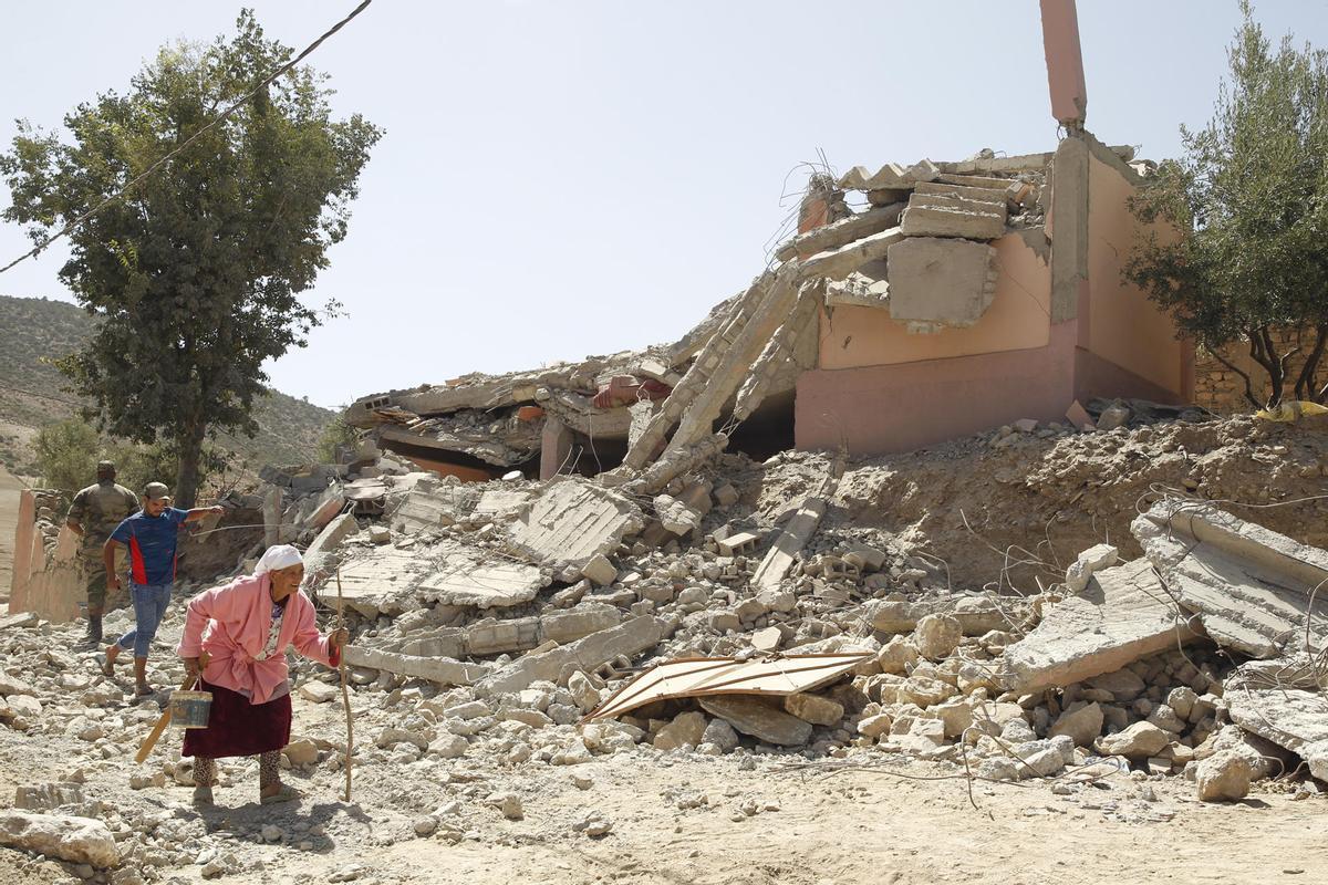 Varias personas caminan entre los escombros en la aldea de Tafagajt, en Marruecos, cerca del epicentro del devastador terremoto en Marruecos.