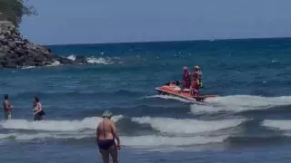 Efectivos de Cruz Roja alertan a los bañistas de San Agustín para que salgan del agua ante la presencia de un tiburón