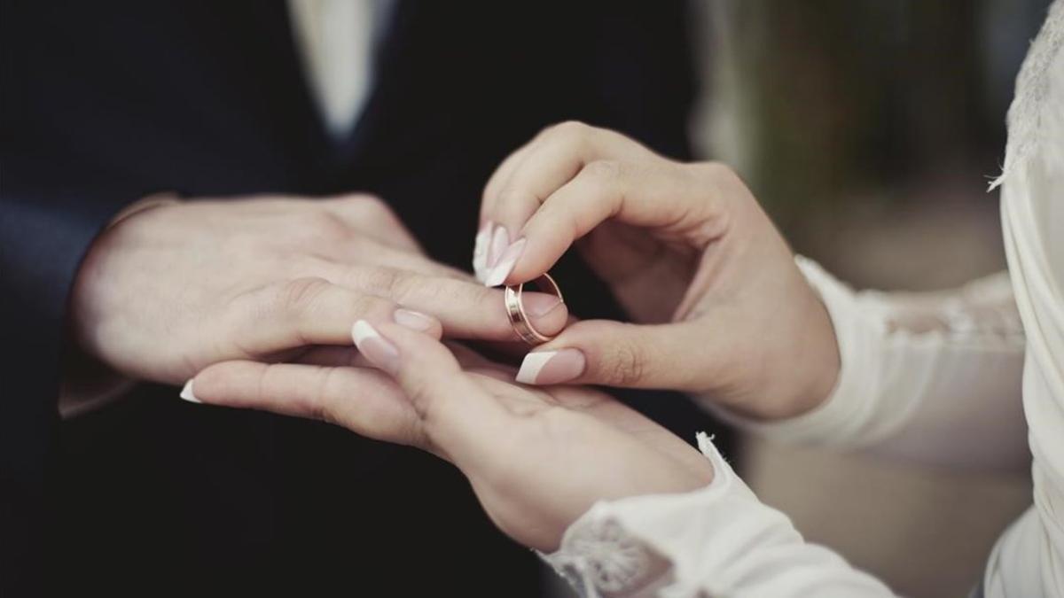 Imagen de una pareja poniéndose los anillos.