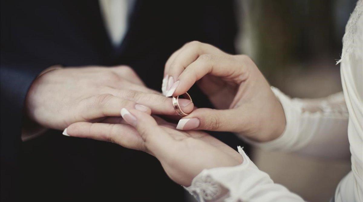 Imagen de una pareja poniéndose los anillos. 