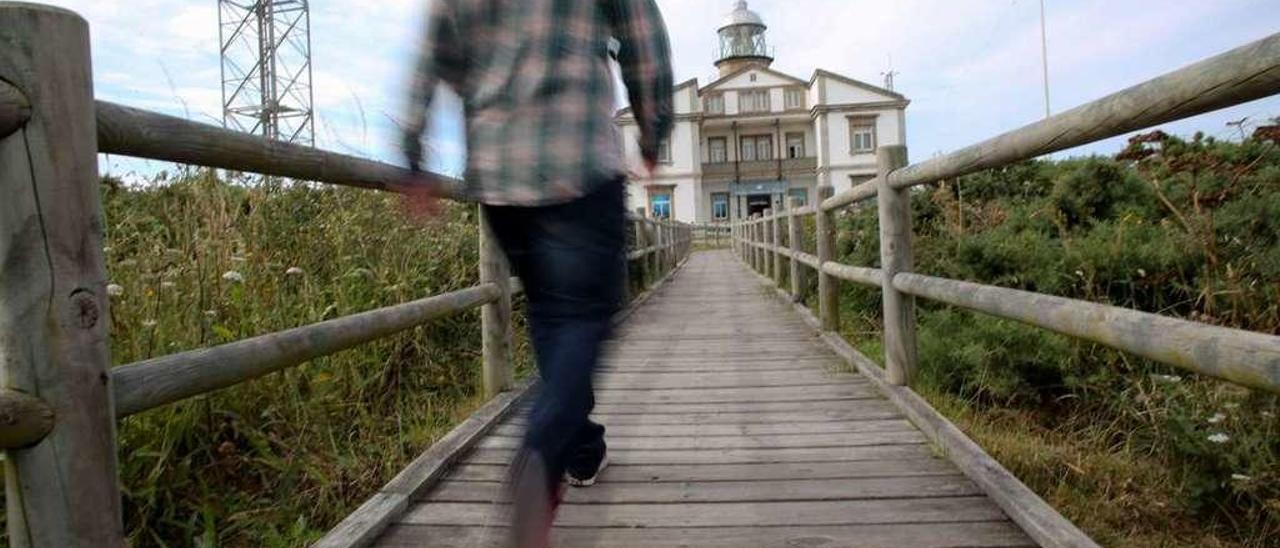 Un hombre camina hacia el faro de Peñas, uno de los enclaves con más gancho turístico del concejo.