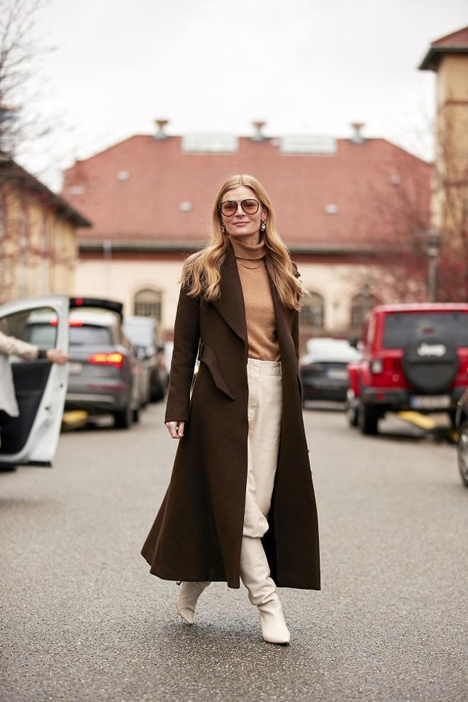 Look con botas blancas altas visto en el 'street style' de invierno de Copenhague