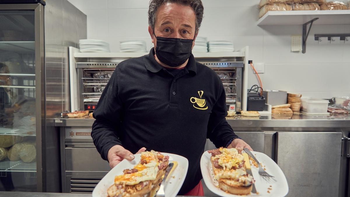 Uno de los camareros posa con las tostadas en la cocina.