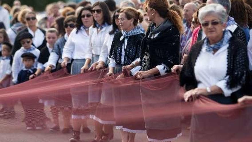 Vecinos de La Arena en la procesión de San Telmo, con red.