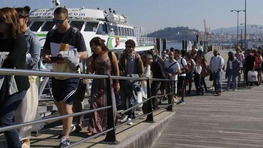 Decenas de visitantes se embarcan en uno de los catamaranes con destino a Cíes. // Alba Villar