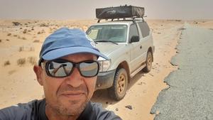 José Manuel Barnuevo, en un selfi en un desierto con su coche en el que lleva viajando más de un año.