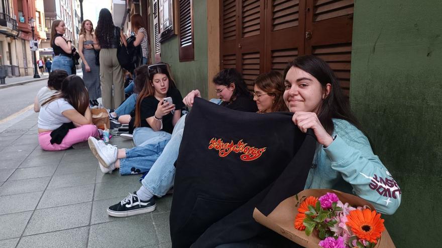 Verónica Clemente, con la sudadera que le regaló Enol y un ramo de flores, ayer, al inicio de la cola que se formó durante toda la tarde a las puertas de la sala Albéniz, donde actuó el artista a las 20.30 y 23.30 horas.