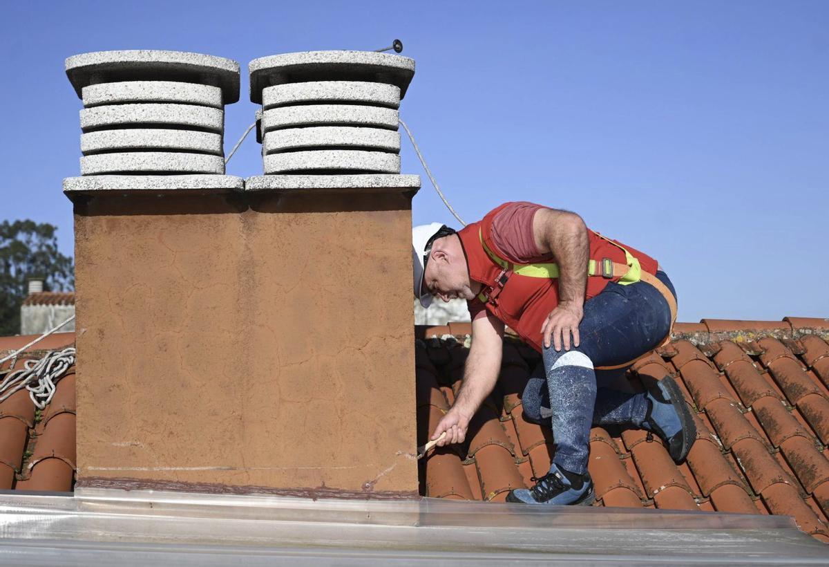 Trabajos de Eulogio Arís en el tejado de un edificio en San Salvador de Poio.