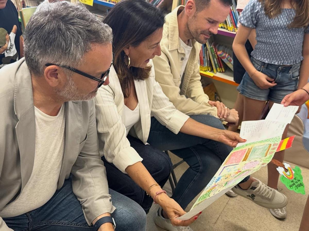 Gilberto Villoria, María López Castro y Carlos Llaca observan unos dibujos.