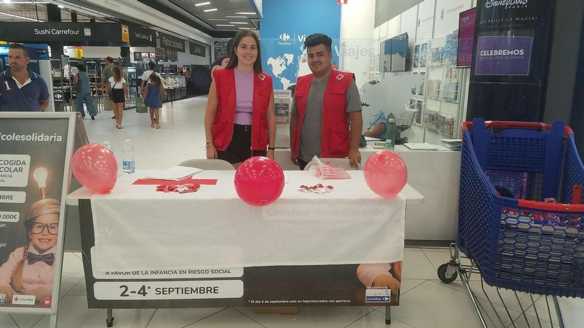 Voluntarios de Cruz Roja recogen material escolar en un Carrefour de Córdoba.