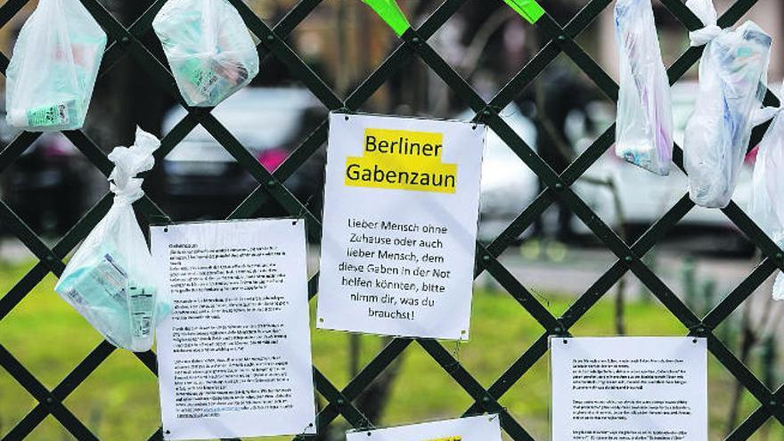 Bolsas con productos de higiene y alimentos para personas sin hogar que ciudadanos cuelgan en Berlín.
