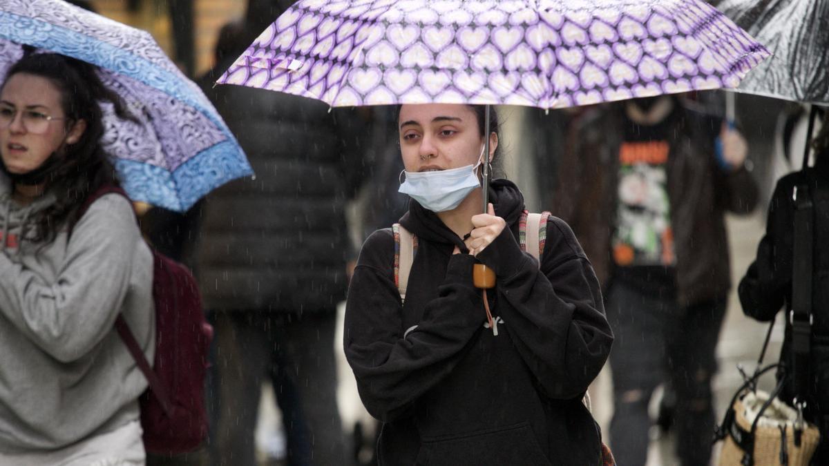 Una joven sujetando un paraguas en un día lluvioso en Murcia.