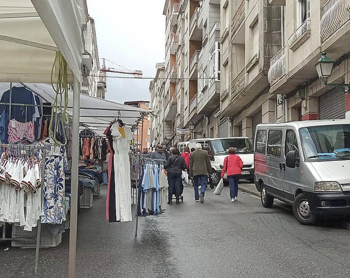 Vehículos aparcados en la acera durante una feria en O Carballiño.