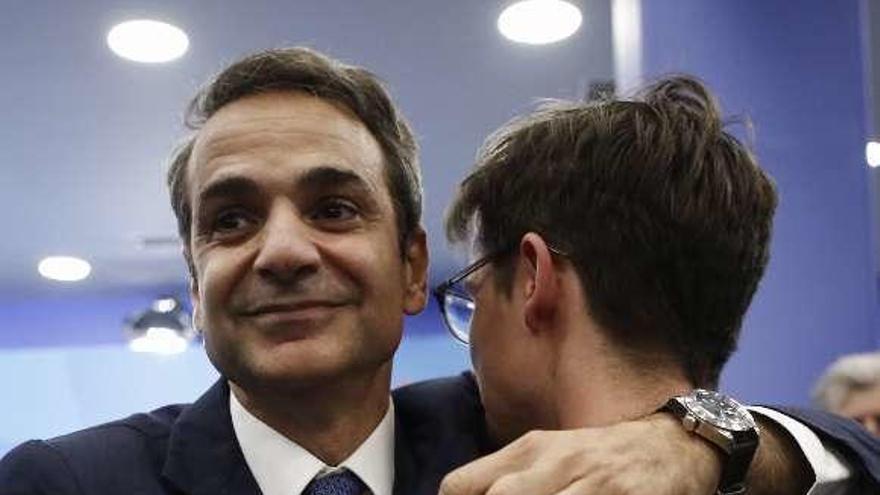 Mitsotakis abraza a su hijo Konstantinos tras la victoria electoral. // Efe