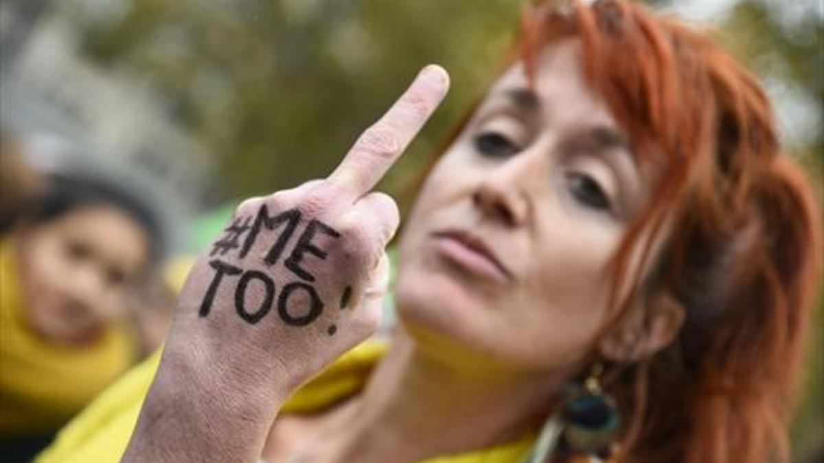 Una mujer con el lema #MeToo escrito en la mano gesticula en París.