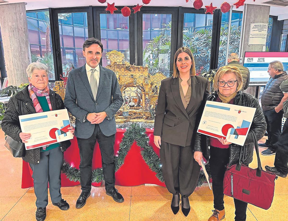 El consejero Jorge García Montoro, junto a la directora general de Vivienda, María Dolores Gil, entregan el diploma a las propietarias de las últimas viviendas cedidas. A la derecha, Isabel Pérez Mata.