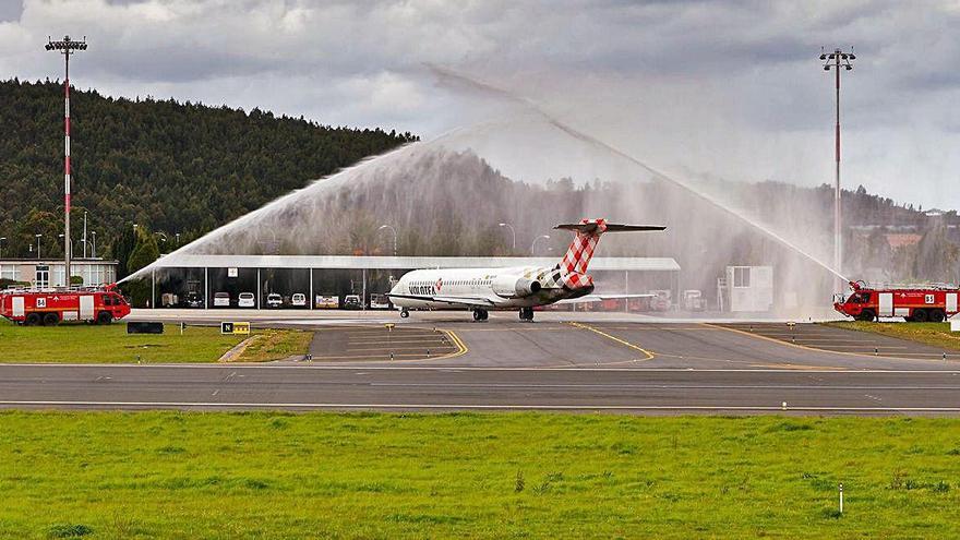 Dos mangueras reciben el primer vuelo de Volotea que aterrizó en Alvedro desde Bilbao, en abril de 2019.