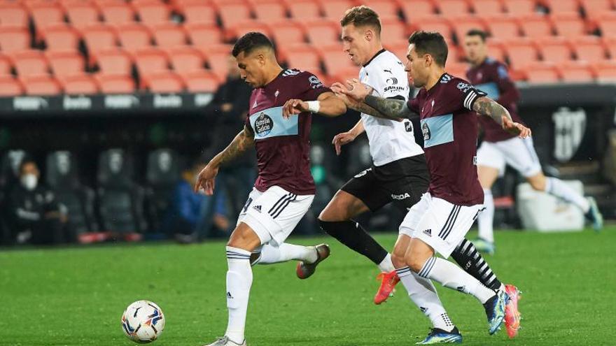 Murillo conduce el balón perseguido por un jugador del Valencia, con Mallo intentando ayudarle. | // E.P.