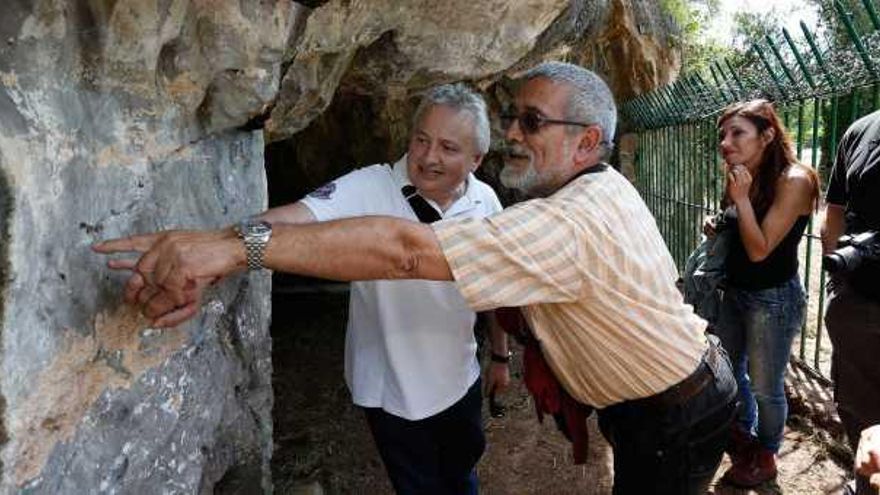 El profesor de Historia en el Aramo Ángel de la Fuente muestra el grabado de una figura solitaria de caballo al segoviano Ismael Simal.