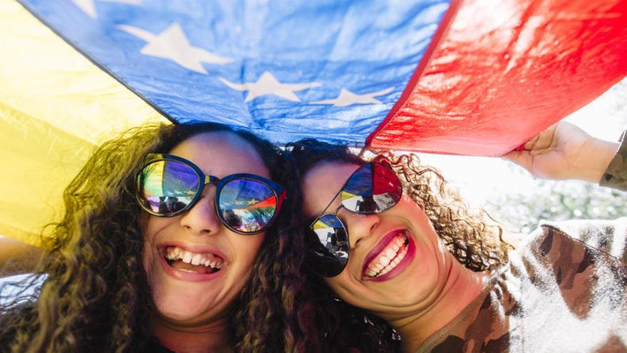 Jóvenes con una bandera de Venezuela.