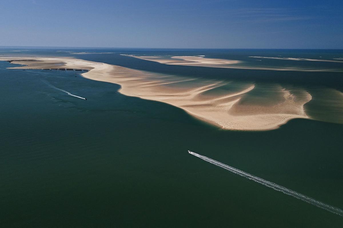 Dos barcos navegan en sentido opuesto frente al banco de arena de Arguin, en el sur de Francia.