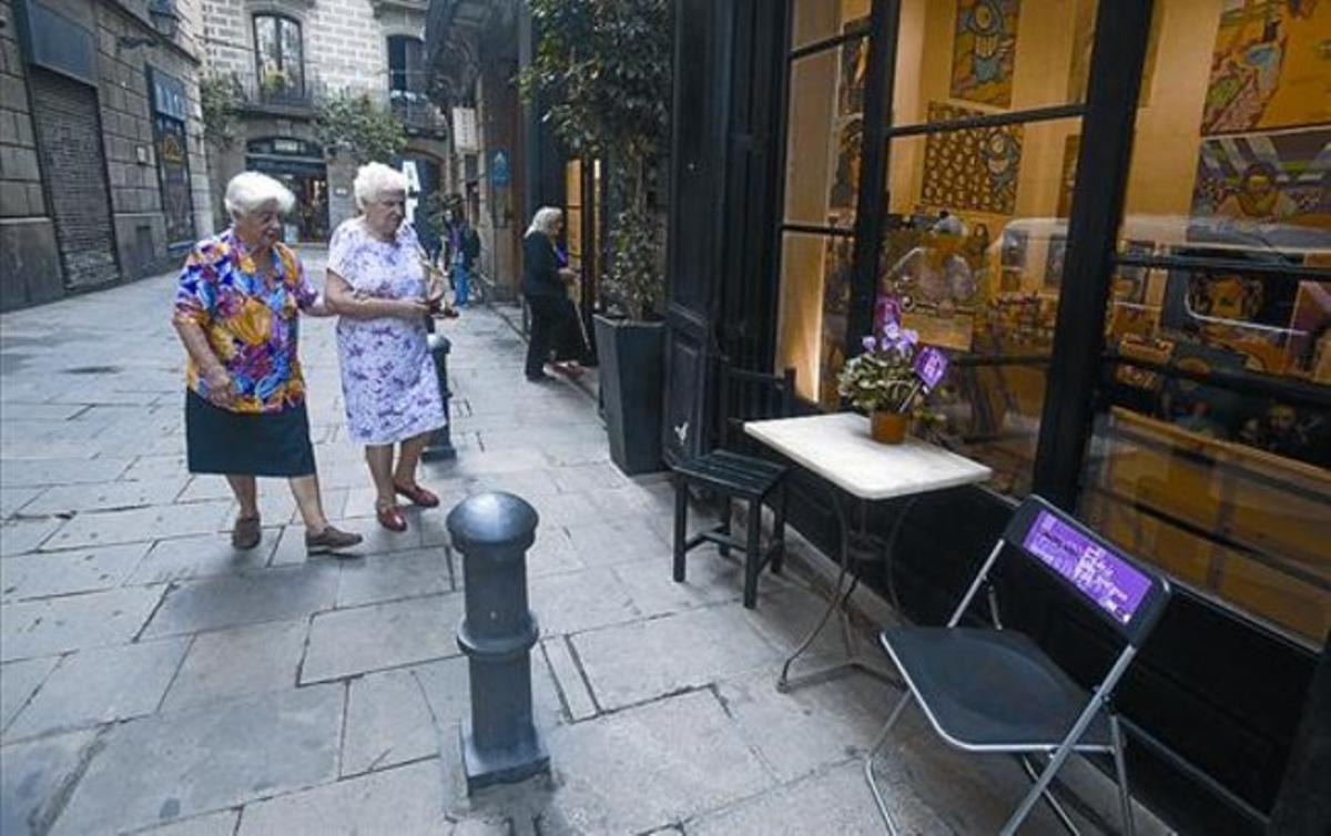 Descans 8 Dues veïnes de Ciutat Vella es disposen a utiizar cadires col·locades pels comerciants.