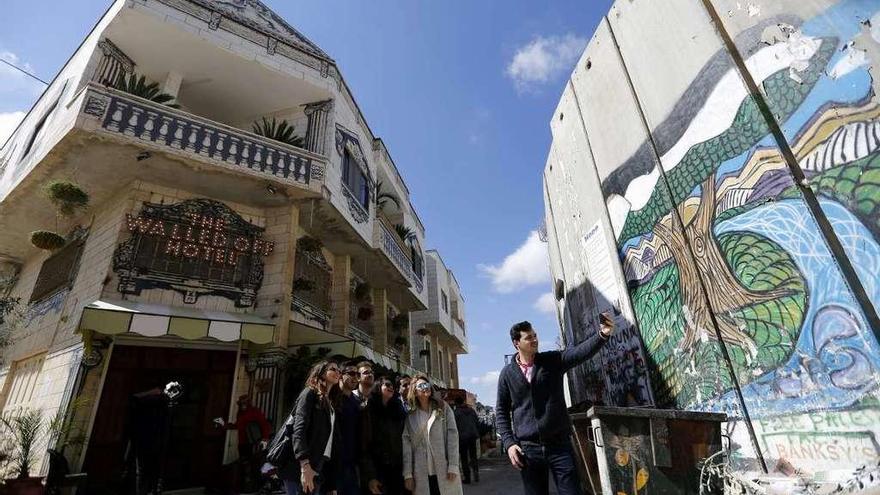 Turistas se hacen un &#039;selfie&#039; frente al hotel de Banksy en Belén.