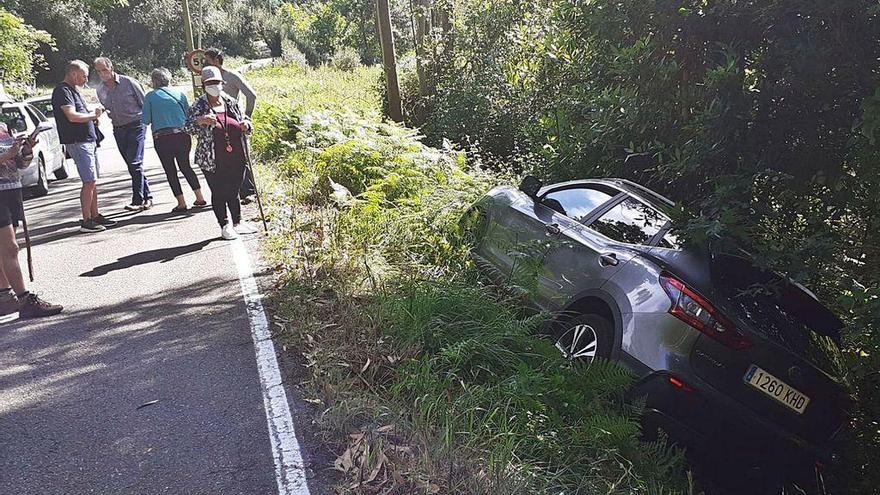 El vehículo volcado, con varios curiosos en el lugar del accidente.