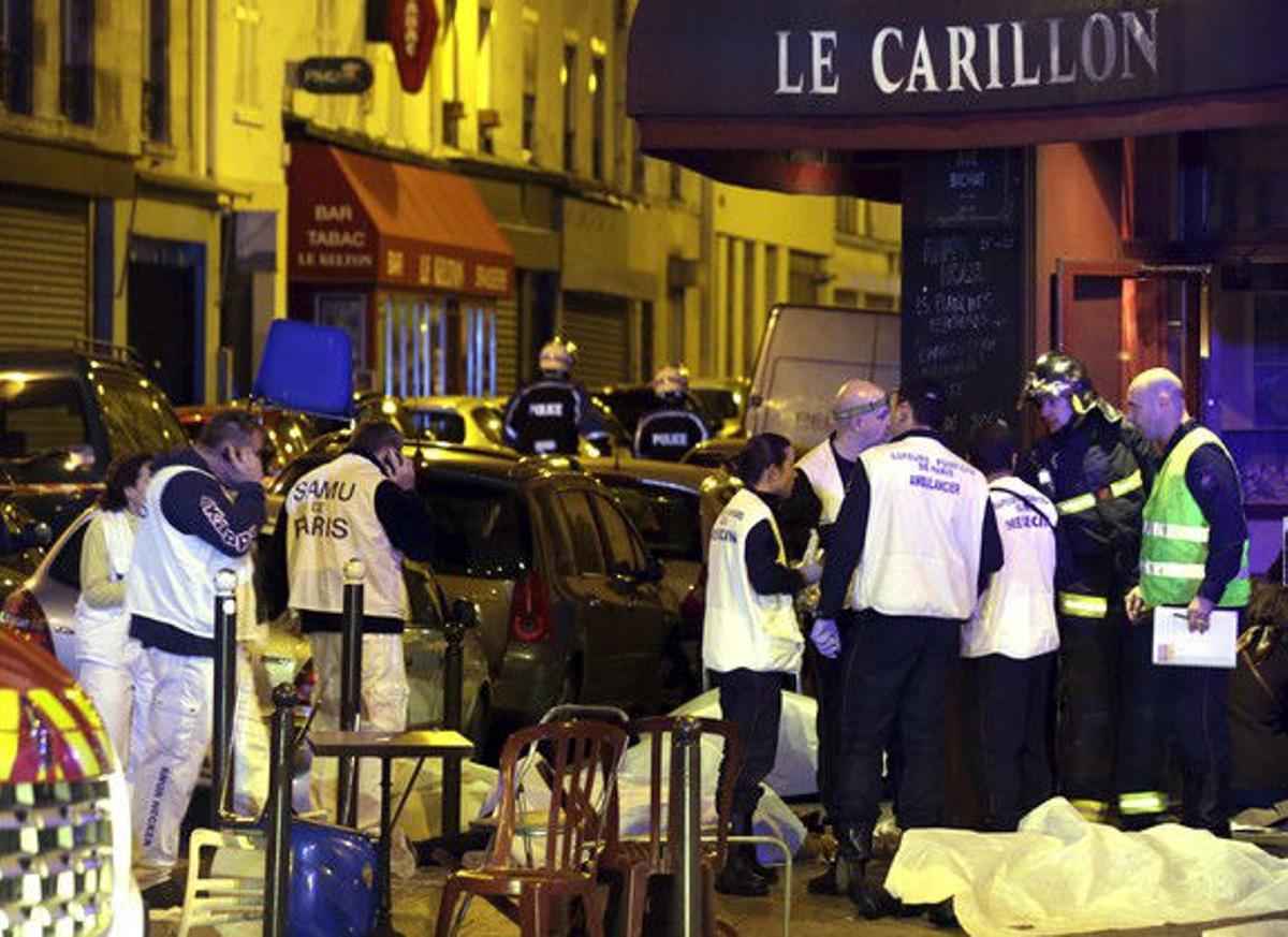 Una vista general de l’escena mostra el personal de servei de rescat que treballen a prop dels cossos coberts fora d’un restaurant després d’un tiroteig a París, França.