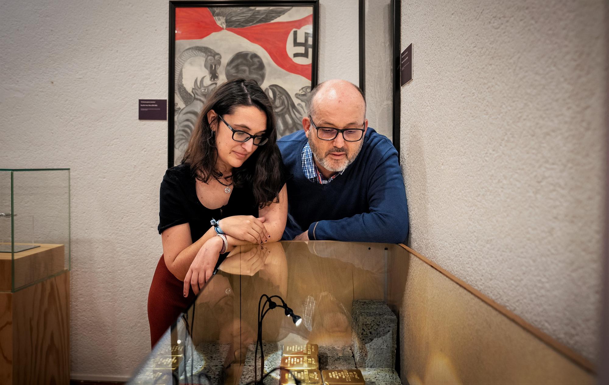 Tania González, comisaria de la exposición, y Agustí Castellano, técnico de patrimonio cultural del Museu de L'Hospitalet, junto a las primeras once 'Stolpersteine'.