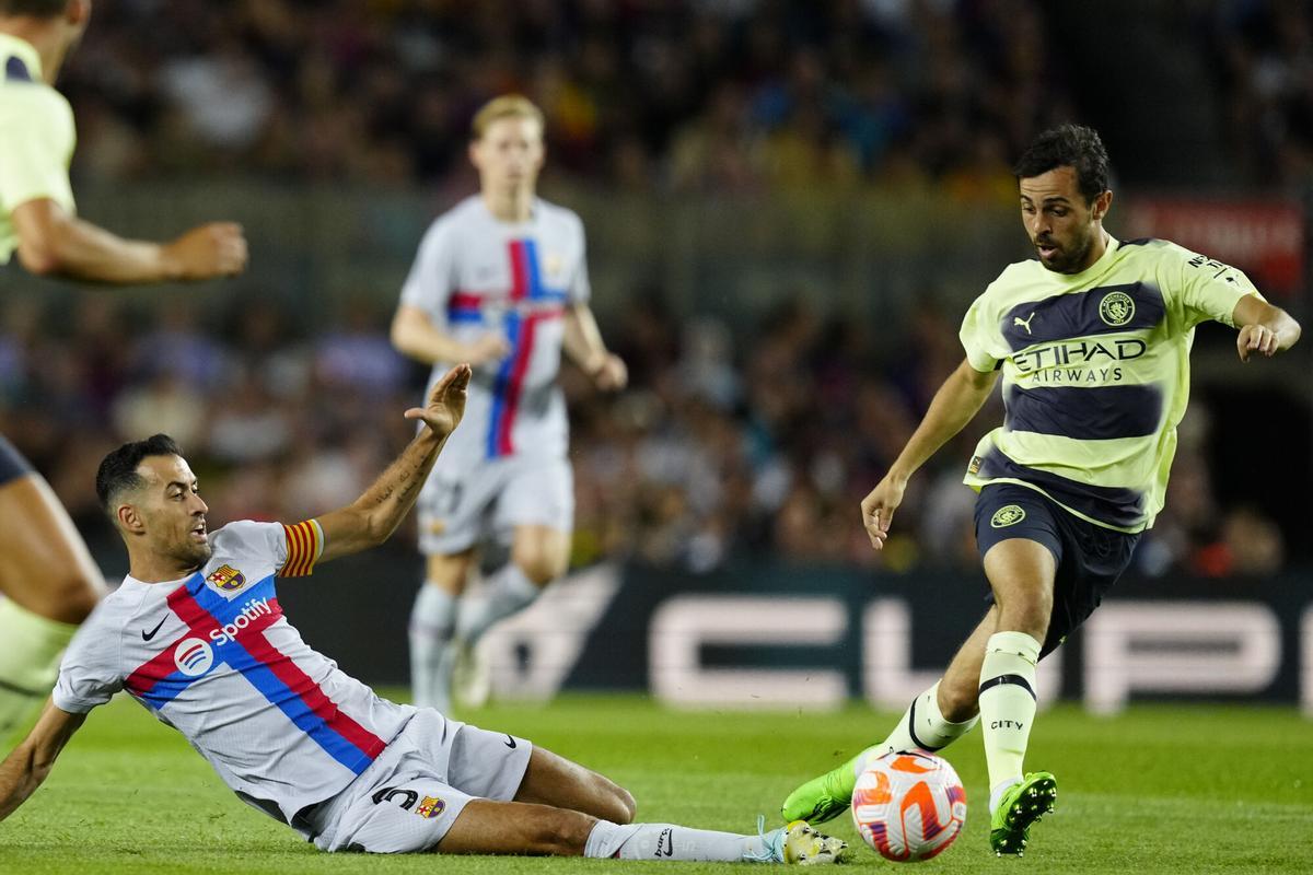 BARCELONA, 24/08/2022.- El jugador del Manchester City Bernardo Silva (d) trata de escapar de Sergio Busquets, del FC Barcelona, durante el partido amistoso que FC Barcelona y Manchester City juegan hoy miércoles en el Camp Nou. EFE/ENRIC FONTCUBERTA