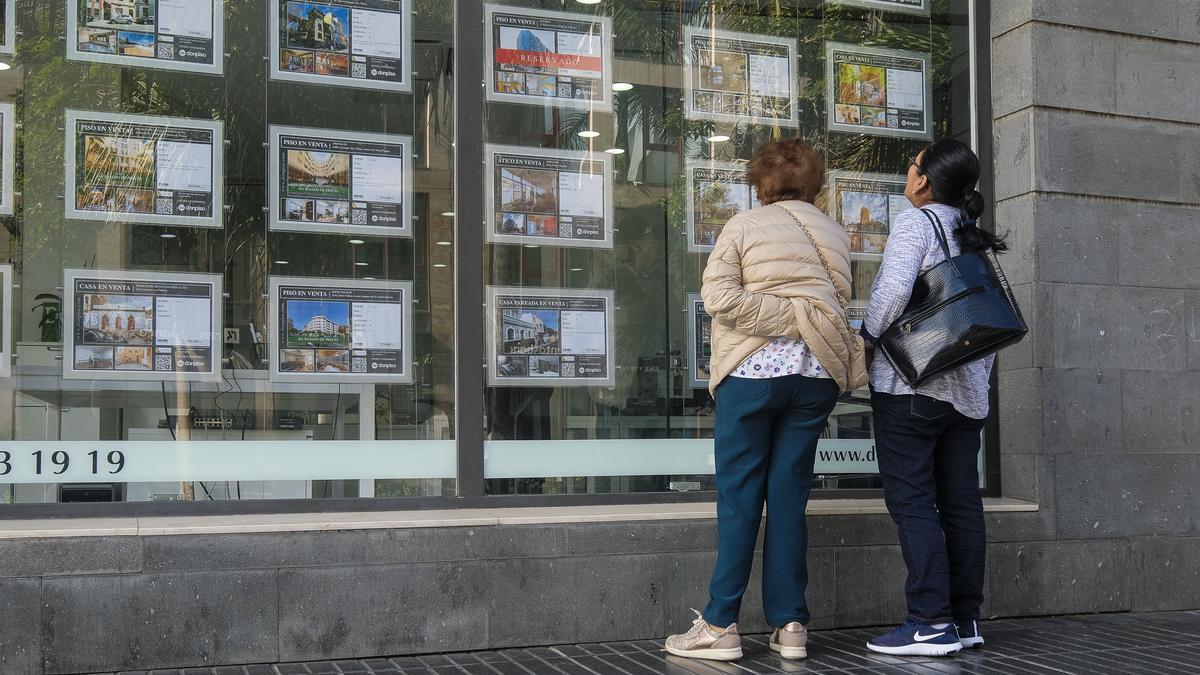 Varias personas miran casas en una inmobiliaria